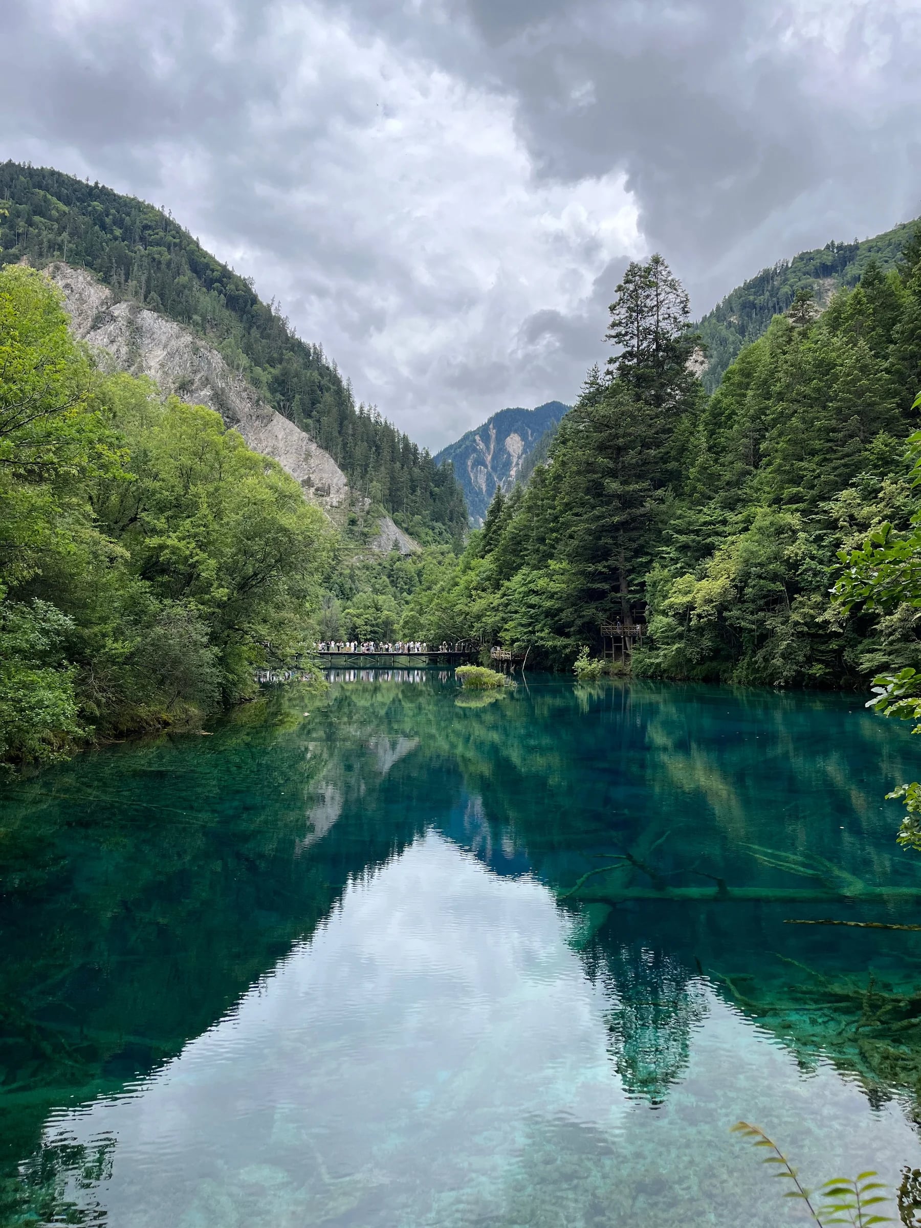 A clear turquoise lake reflecting forested mountains in Jiuzhaigou